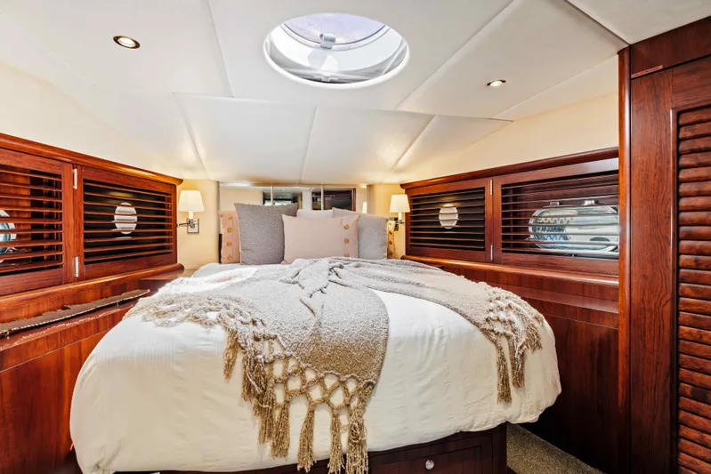 Infinite Yacht Photos Pics Luxurious bedroom interior of 1999 Warren Yachts 85 Motor Yacht with elegant wood finishes.