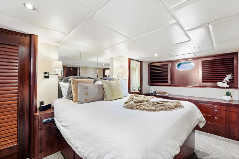 Infinite Yacht Photos Pics Luxurious bedroom interior of 1999 Warren Yachts 85 Motor Yacht with elegant wood finishes.