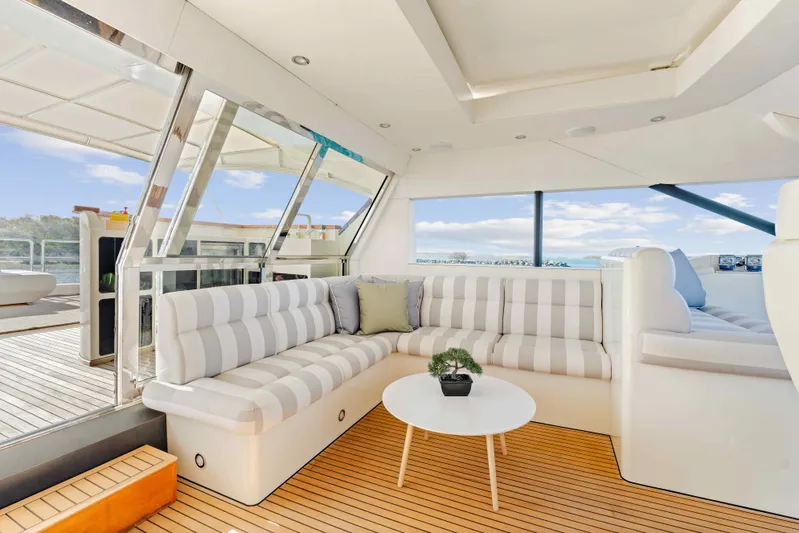 Infinite Yacht Photos Pics Luxurious interior of 1999 Warren Yachts 85 Motor Yacht with striped seating and wooden flooring.