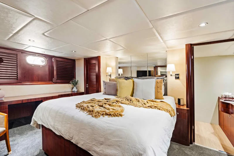 Infinite Yacht Photos Pics Luxurious bedroom interior of 1999 Warren Yachts 85 Motor Yacht with elegant wood finishes.