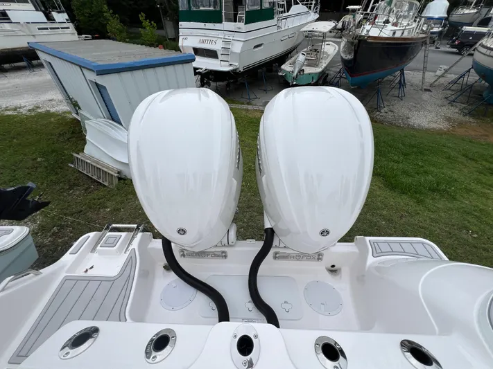  Yacht Photos Pics 2025 Sea Fox 288 Commander with dual outboard engines in a boatyard setting.