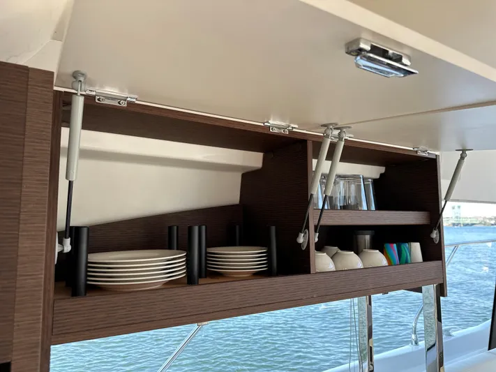 Meanwhile Yacht Photos Pics Prestige 420 S 2021 yacht interior with open cabinet displaying dishes and glassware.