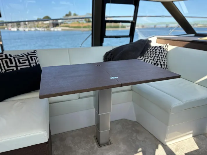 Meanwhile Yacht Photos Pics Interior of 2021 Prestige 420 S yacht with a wooden table and white seating.
