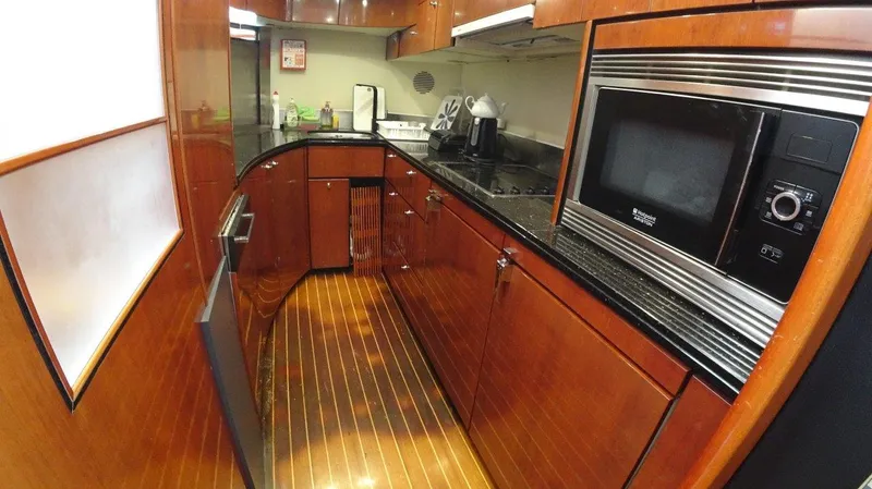  Yacht Photos Pics Luxurious kitchen in 2004 Fairline Squadron 74 yacht with wood cabinetry and modern appliances.