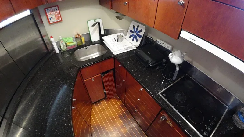  Yacht Photos Pics Luxurious kitchen in 2004 Fairline Squadron 74 yacht with sleek countertops and wooden cabinetry.