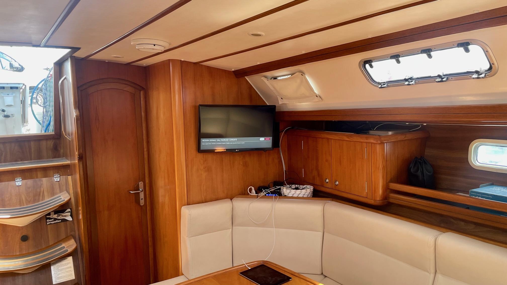 Luxurious yacht interior with wood paneling, TV, and seating, Alpha 51 model, 2003.