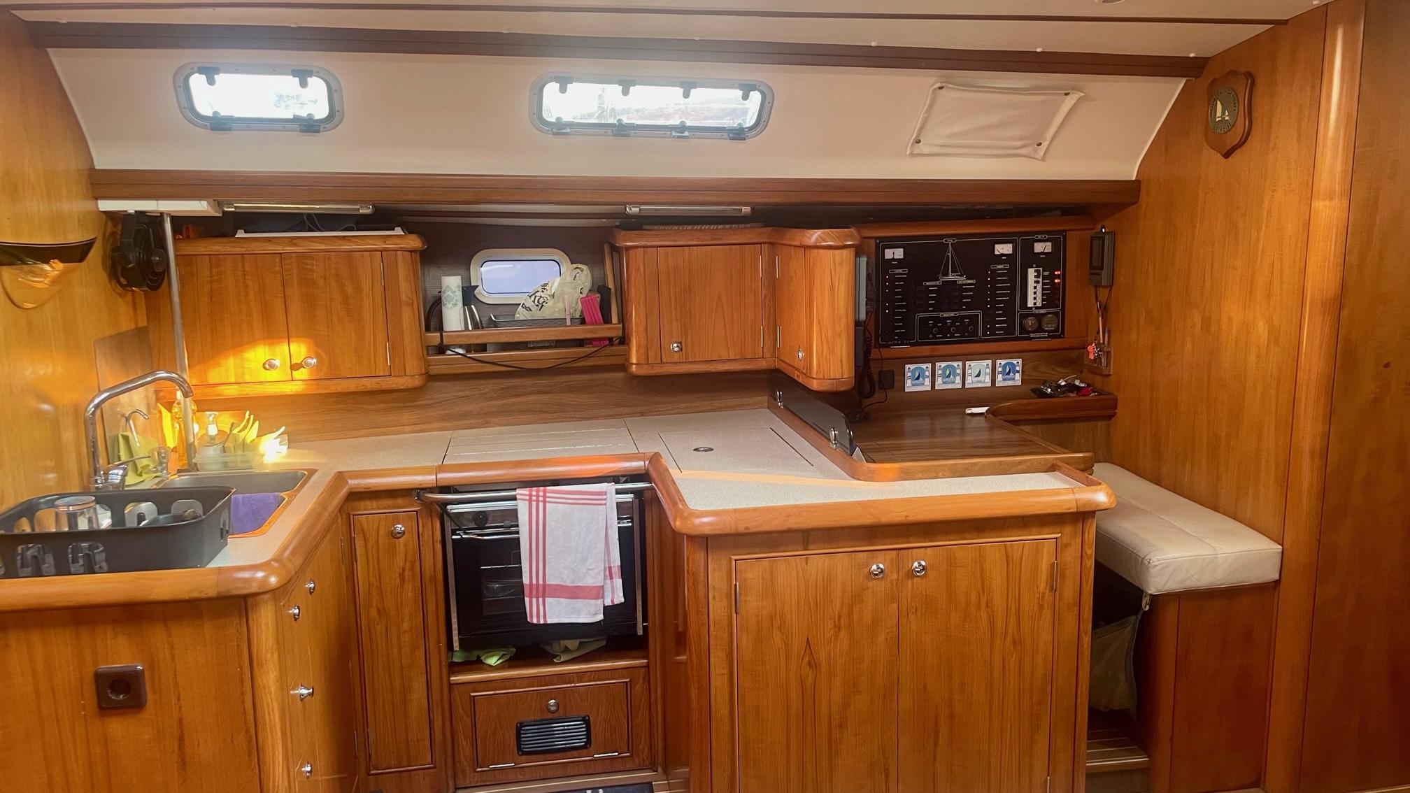 Interior of 2003 Alpha 51 yacht kitchen with wooden cabinets and modern appliances.