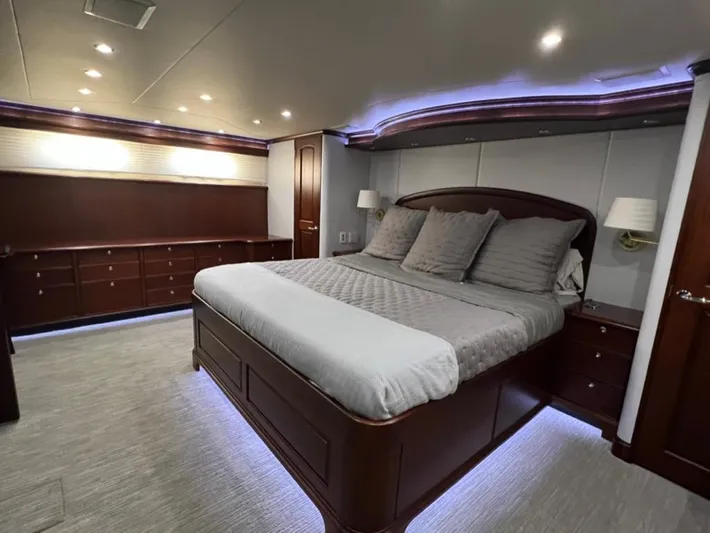 Lucky Again Yacht Photos Pics Luxurious bedroom in 2005 Pacific Mariner 85 yacht with elegant wood finishes and ambient lighting.