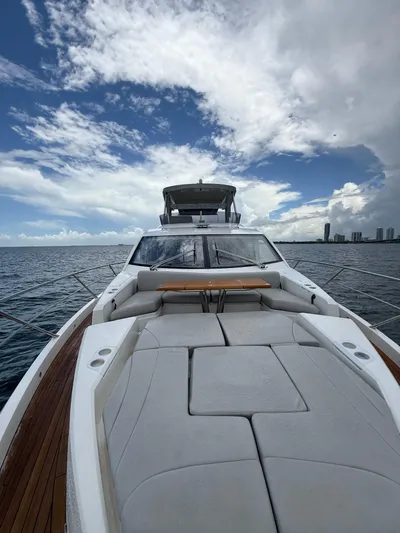 4 Play Yacht Photos Pics 2022 Sunseeker Manhattan 68 yacht with spacious deck, ocean view, and cloudy sky.