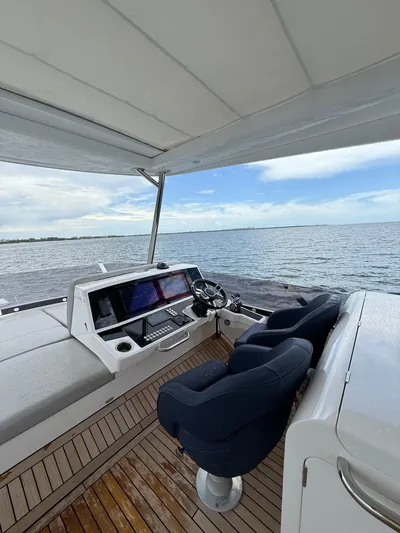 4 Play Yacht Photos Pics Sunseeker Manhattan 68 yacht helm, 2022 model, overlooking serene ocean view.
