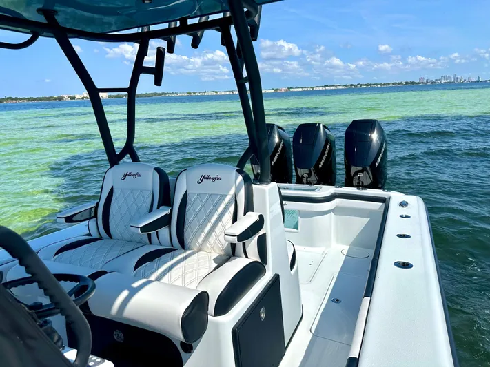  Yacht Photos Pics 2024 Yellowfin 36 boat with triple outboard engines on clear blue water.