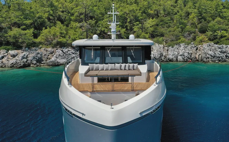 Tortura Yacht Photos Pics 2025 Aegean Explorer yacht docked in serene, turquoise waters with lush greenery backdrop.