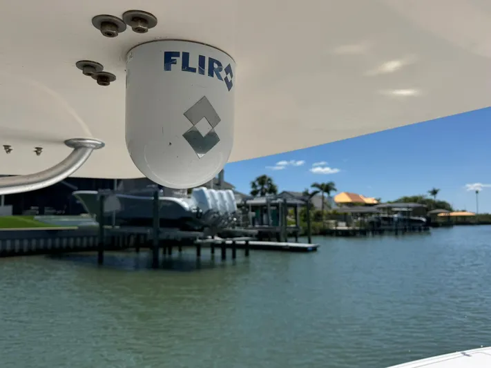  Yacht Photos Pics FLIR camera on 2006 Intrepid 323 boat, docked near waterfront homes under clear blue sky.