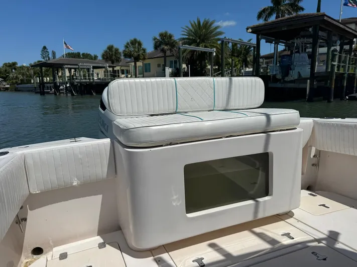  Yacht Photos Pics 2006 Intrepid 323 boat interior with cushioned seating, docked by waterfront homes.