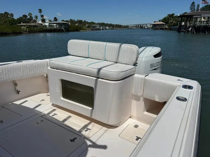  Yacht Photos Pics 2006 Intrepid 323 boat with Suzuki engine, featuring cushioned seating and scenic waterway view.