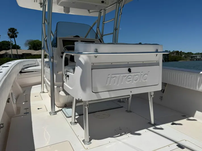  Yacht Photos Pics 2006 Intrepid 323 boat interior with seating and console, under clear blue sky.