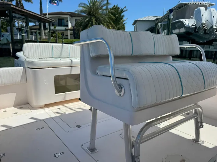  Yacht Photos Pics 2006 Intrepid 323 boat with white cushioned seating, docked near waterfront homes.