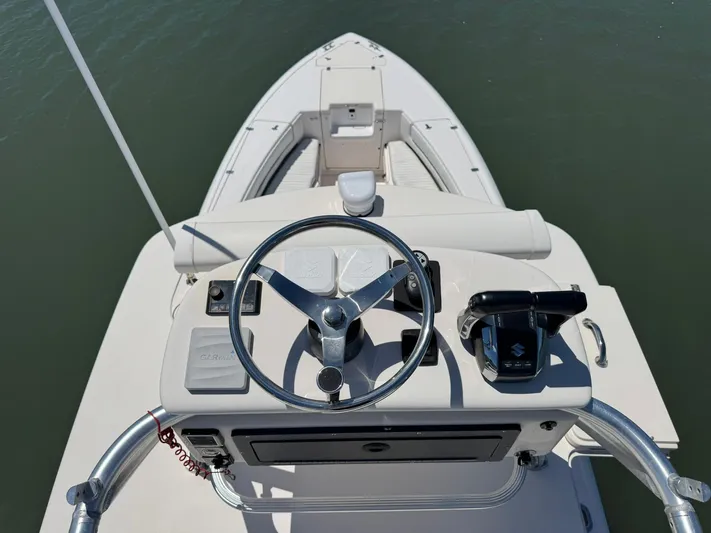  Yacht Photos Pics 2006 Intrepid 323 boat helm with steering wheel and controls, on calm water.
