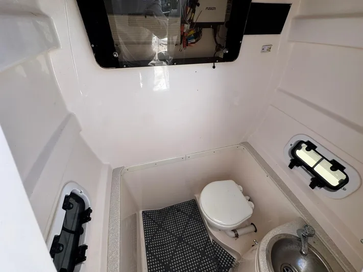  Yacht Photos Pics Compact marine bathroom in a 2006 Intrepid 323 boat, featuring a toilet and sink.