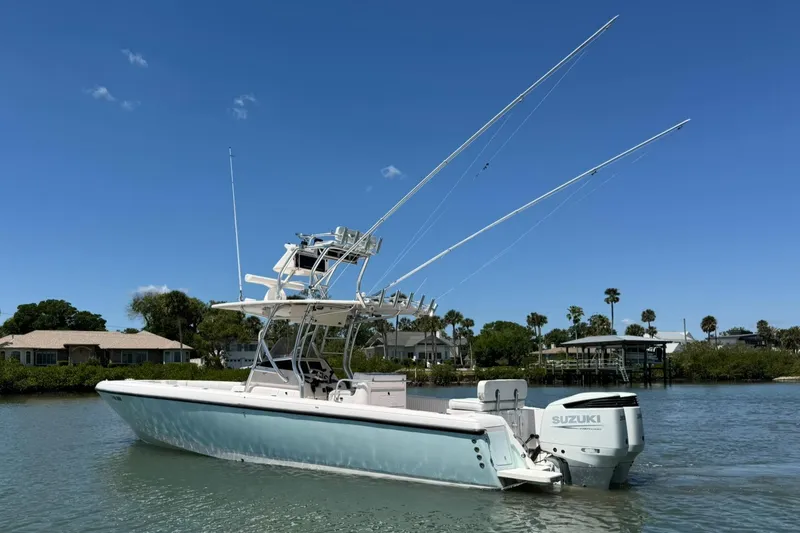  Yacht Photos Pics 2006 Intrepid 323 boat with Suzuki engine on calm water, clear blue sky background.