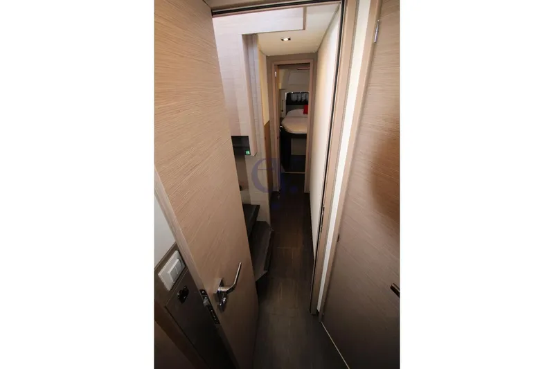  Yacht Photos Pics Interior hallway of 2021 Fountaine Pajot Astrea 42 catamaran, featuring modern wood finishes.