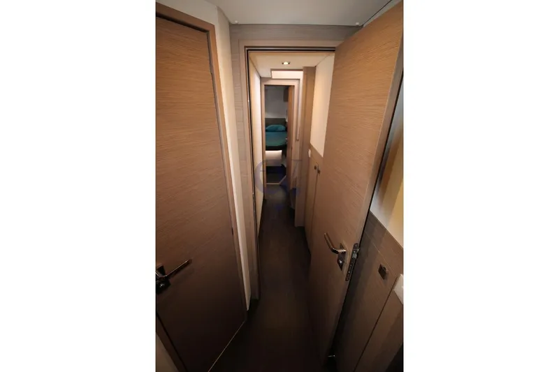  Yacht Photos Pics Narrow hallway inside 2021 Fountaine Pajot Astrea 42 catamaran, featuring wooden doors and modern design.