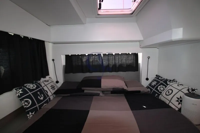  Yacht Photos Pics Cozy cabin interior of 2021 Fountaine Pajot Astrea 42 with nautical-themed bedding.