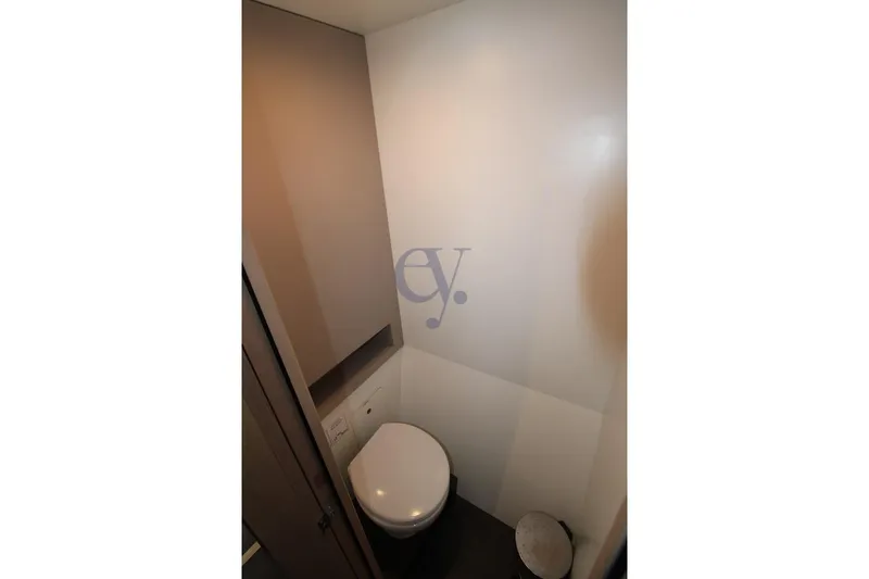  Yacht Photos Pics Compact bathroom in 2021 Fountaine Pajot Astrea 42 yacht, featuring modern toilet and storage.