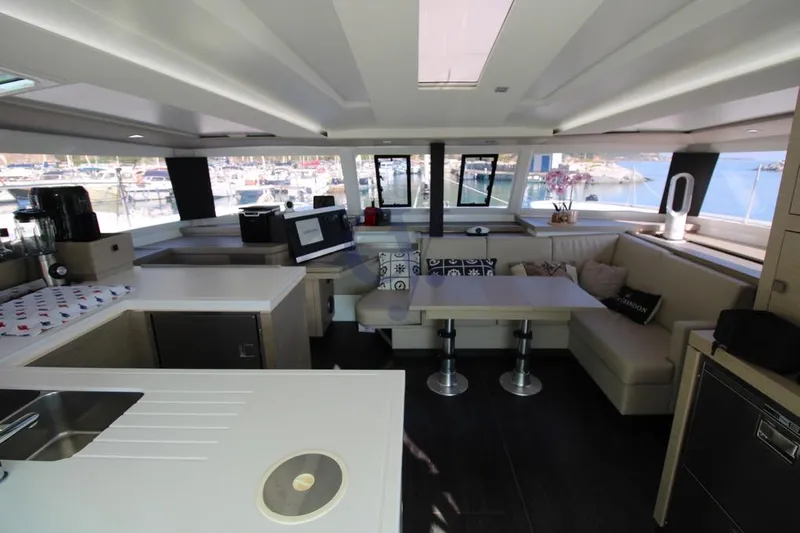  Yacht Photos Pics Luxurious interior of 2021 Fountaine Pajot Astrea 42 catamaran with modern kitchen and seating area.