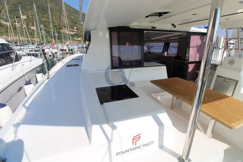  Yacht Photos Pics 2021 Fountaine Pajot Astrea 42 yacht deck with dining area and marina view.