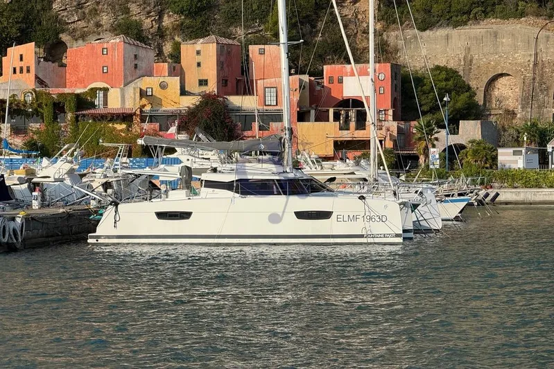  Yacht Photos Pics 2021 Fountaine Pajot Astrea 42 catamaran docked in a vibrant marina setting.