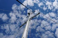 Tall sailboat mast against a blue sky with clouds, Scandinavian Cruiser Eagle, 1989.