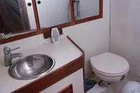 Compact bathroom in 1989 Scandinavian Cruiser Eagle with sink, toilet, and mirrored cabinet.
