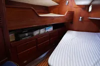 Cozy cabin interior of 1989 Scandinavian Cruiser Eagle with wooden furnishings and striped bedding.