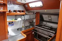 Compact kitchen in 1989 Scandinavian Cruiser Eagle with stainless steel counters and wooden cabinetry.