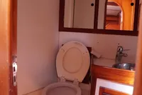 1989 Scandinavian Cruiser Eagle bathroom with wooden cabinets and compact toilet.
