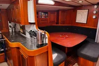 Cozy interior of 1989 Scandinavian Cruiser Eagle with wooden cabinetry and dining area.