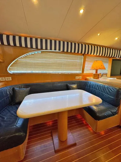  Yacht Photos Pics Interior of 1999 Bertram 60 Convertible yacht with cozy seating and elegant table.