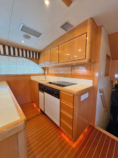  Yacht Photos Pics 1999 Bertram 60 Convertible yacht kitchen with wood cabinetry and modern appliances.