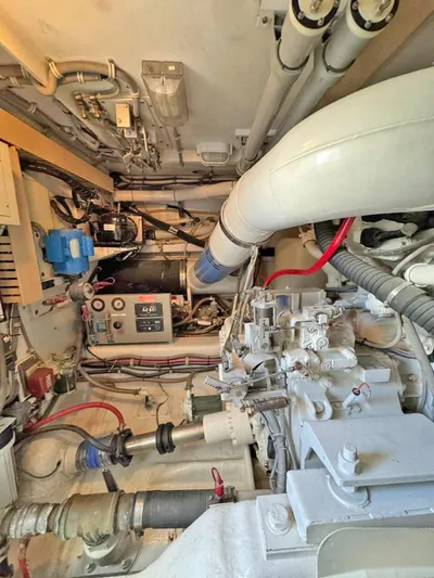  Yacht Photos Pics Engine room of a 1999 Bertram 60 Convertible yacht, showcasing mechanical components and piping.
