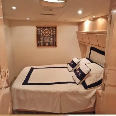  Yacht Photos Pics Luxurious bedroom interior of 1999 Bertram 60 Convertible yacht with nautical decor.
