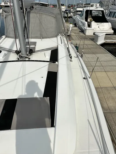 Chasing Summer Yacht Photos Pics 2022 Beneteau Oceanis 46.1 sailboat docked at marina, showcasing deck and rigging.