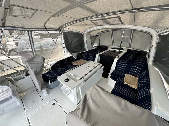 Chasing Summer Yacht Photos Pics Interior of 2022 Beneteau Oceanis 46.1 yacht with striped seating and covered deck.