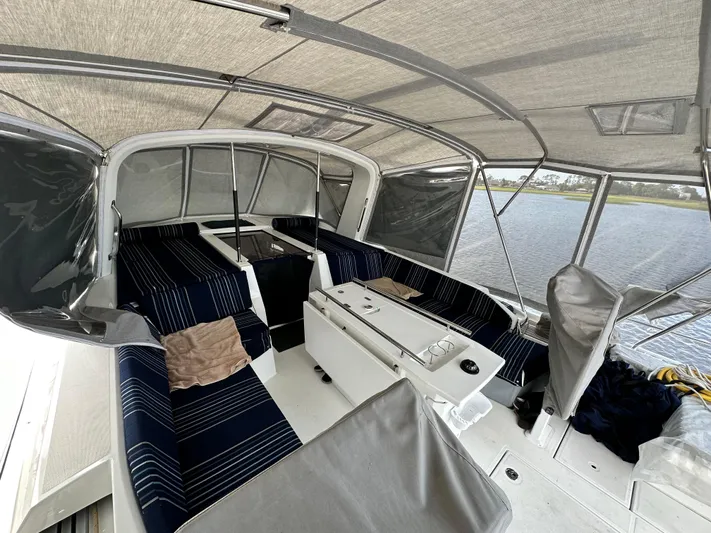 Chasing Summer Yacht Photos Pics Interior view of 2022 Beneteau Oceanis 46.1 sailboat with striped seating and covered deck.