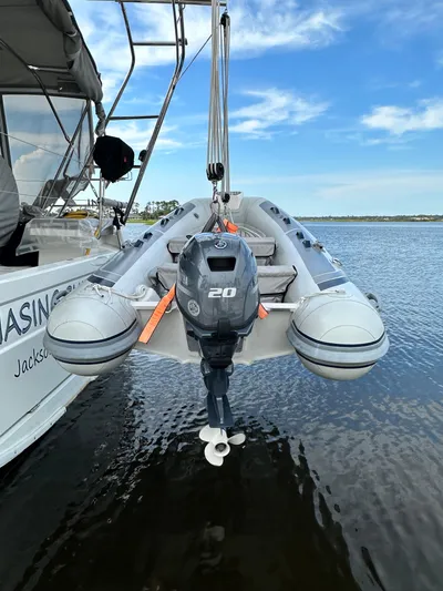 Chasing Summer Yacht Photos Pics A 2022 Beneteau Oceanis 46.1 with a dinghy and outboard motor on calm water.