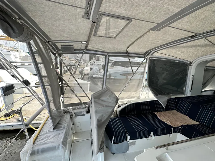 Chasing Summer Yacht Photos Pics Interior view of 2022 Beneteau Oceanis 46.1 yacht with covered seating area.