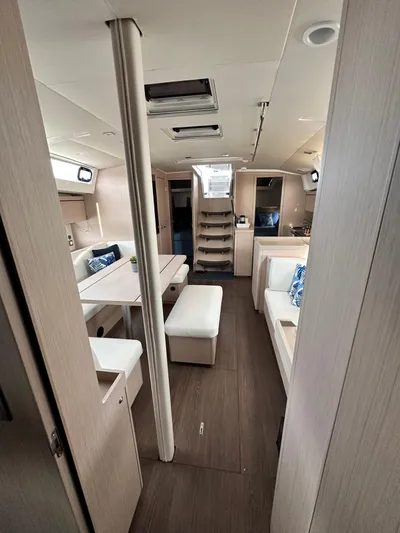 Chasing Summer Yacht Photos Pics Interior of 2022 Beneteau Oceanis 46.1 yacht, featuring modern seating and wooden flooring.