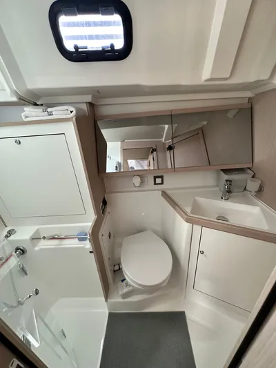 Chasing Summer Yacht Photos Pics Modern bathroom in 2022 Beneteau Oceanis 46.1 yacht, featuring sleek design and compact amenities.
