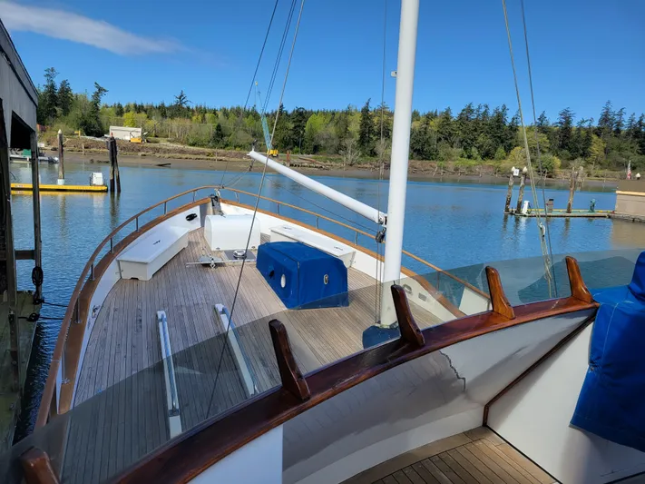 Shackleton Yacht Photos Pics 1982 Miller Marine North Sea Trawler docked, showcasing wooden deck and serene waterfront view.