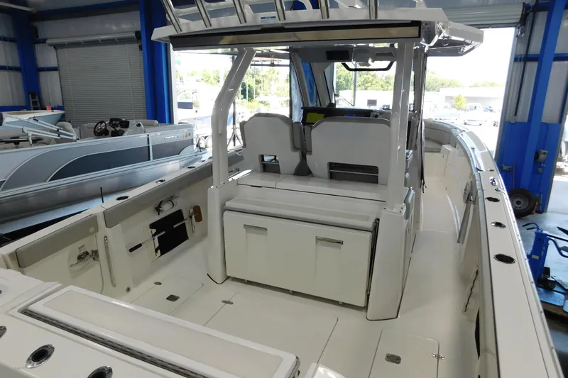 Three Point O.h. Yacht Photos Pics 2022 Pursuit S 328 Sport boat interior, featuring spacious seating and modern design in a showroom.